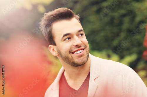 Young happy man in the park in autumn