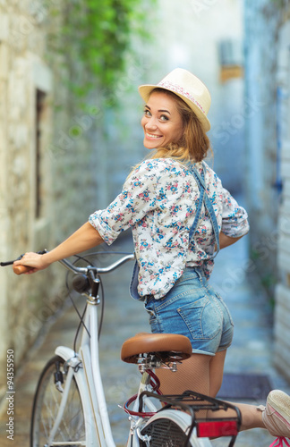 Happy woman with bicycle on street of old town