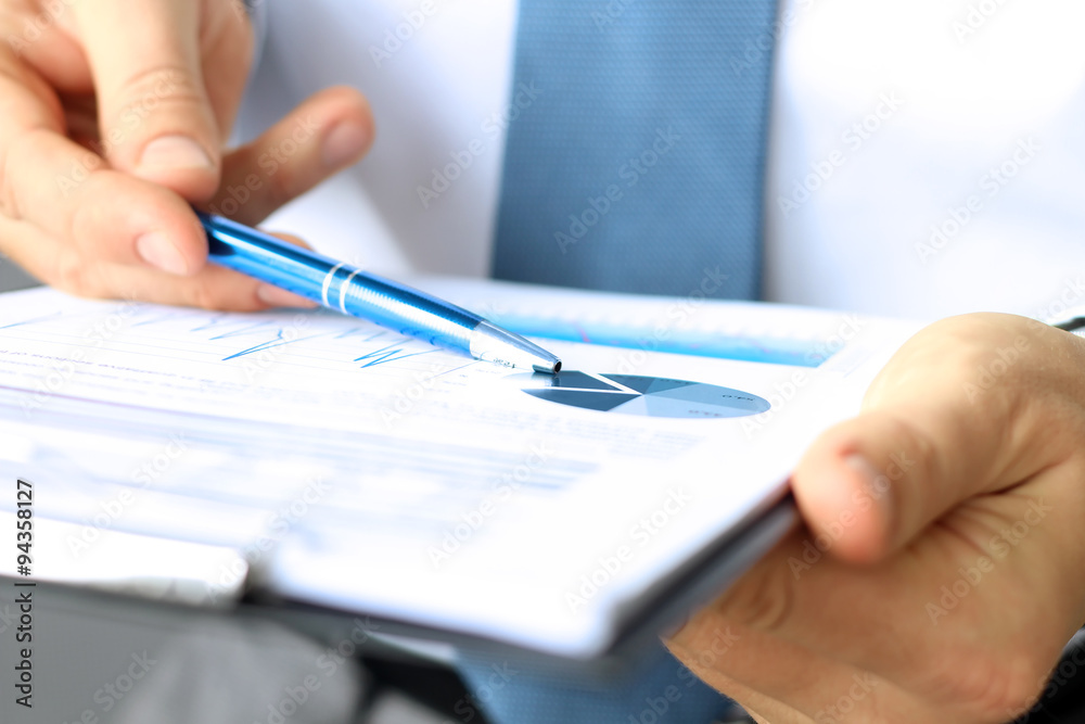 The young businessman showing graphs by pen