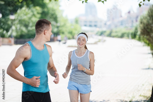 Young couple jogging in park at morning. Health and fitness.