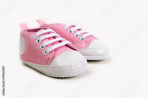 Pink baby girl shoes on a wooden floor outdoors