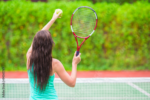 Young active sporty woman playing tennis on tropical vacation