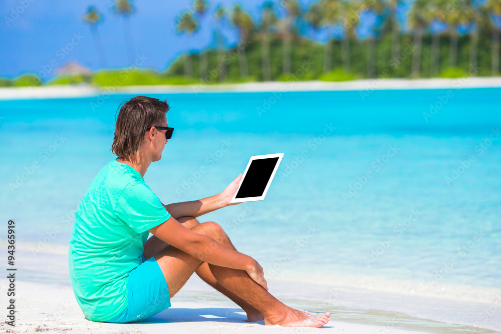 Young man make a photo with laptop at tropical beach