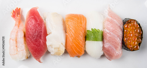 Various Japanese sushi in white plate over white background