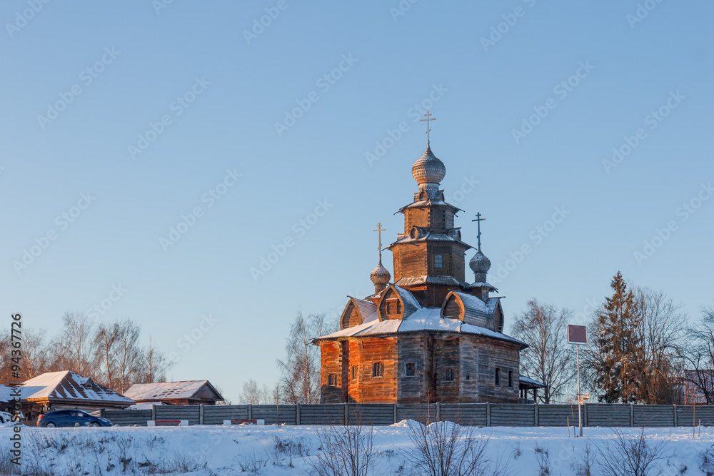 Fototapeta Winter landscape in the early frosty morning in Suzdal with the old wooden church. Transfiguration Church in the Museum of Wooden Architecture
