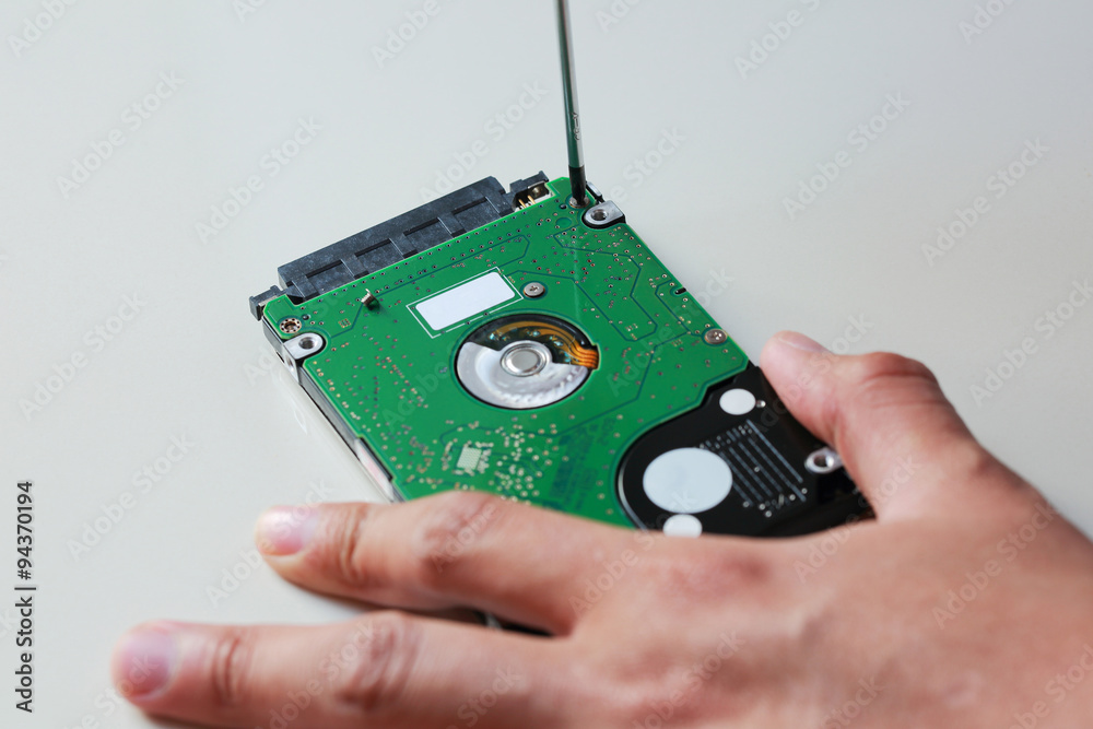 hand with screwdriver repairing hard drive hand with screwdriver repairing hard drive