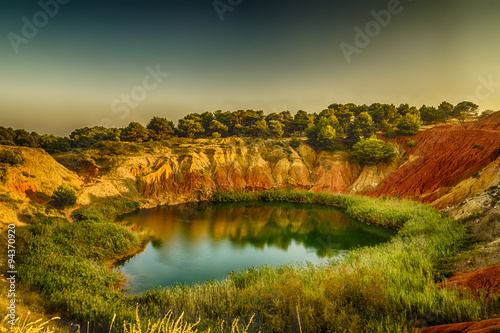 red soils around the lake in bauxite quarry photo