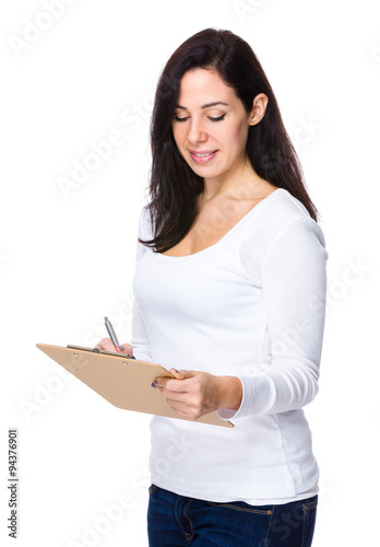 Brunette woman take note on clipboard