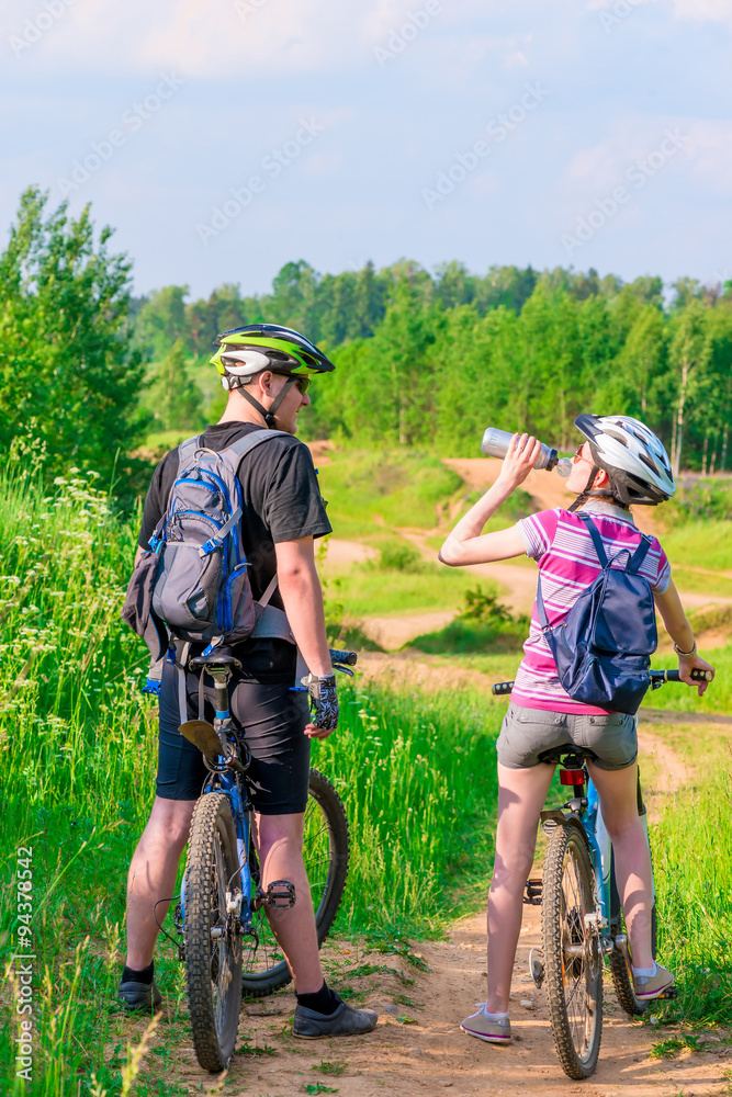 young athletes on bicycles rest and drink water young athletes on bicycles rest and drink water
