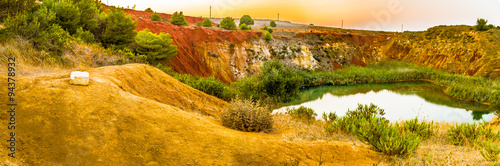 red soils around the lake in bauxite quarry photo