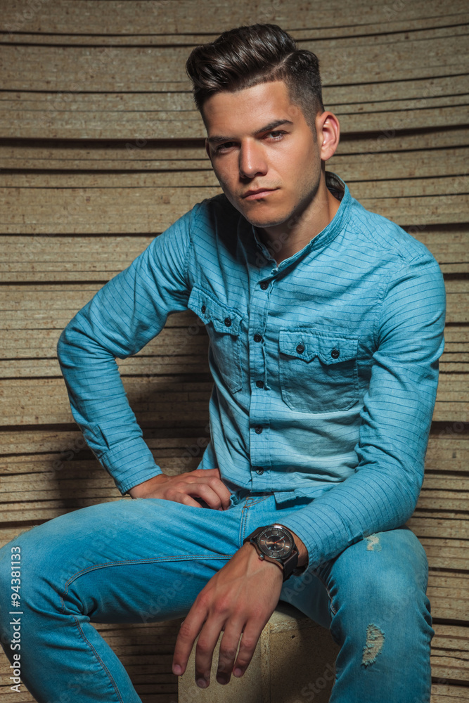 man in wooden studio sitting on a chair and posing man in wooden studio sitting on a chair and posing