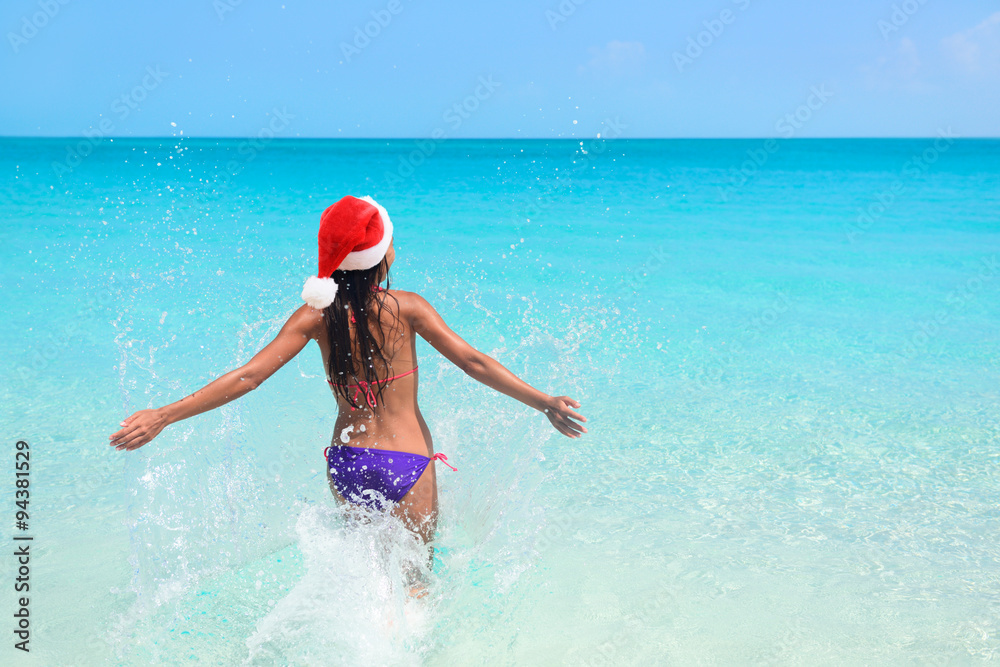 Christmas beach bikini woman swimming in ocean