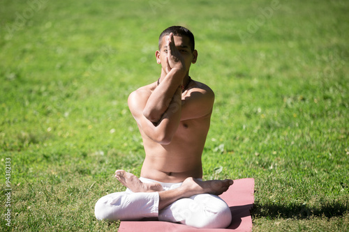 Lotus Pose with Eagle Arms in park photo