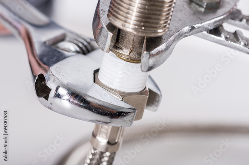Fotografija Plumber screwing plumbing fittings