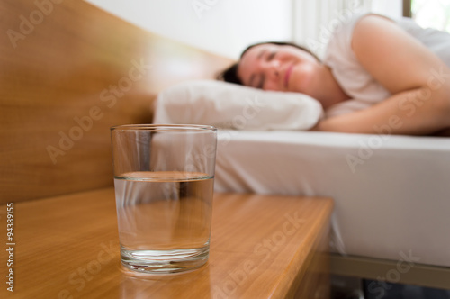 woman sleeping with water on the night table