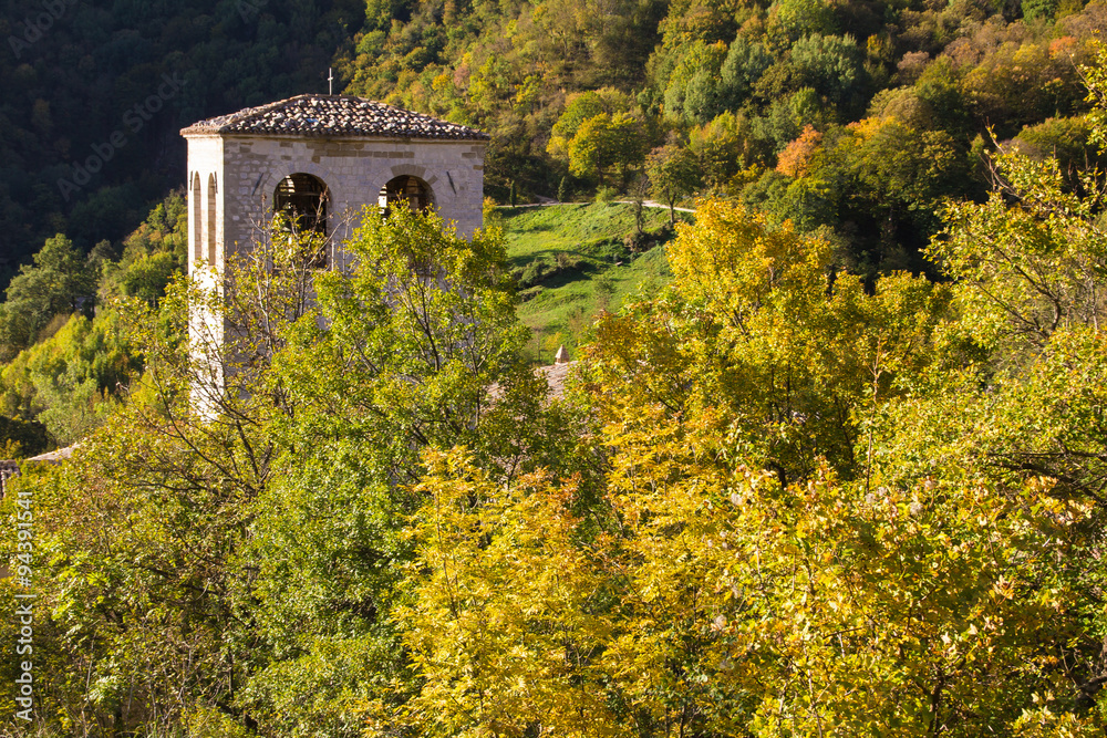 Campanile del monastero di Fonte Avellana tra gli alberi