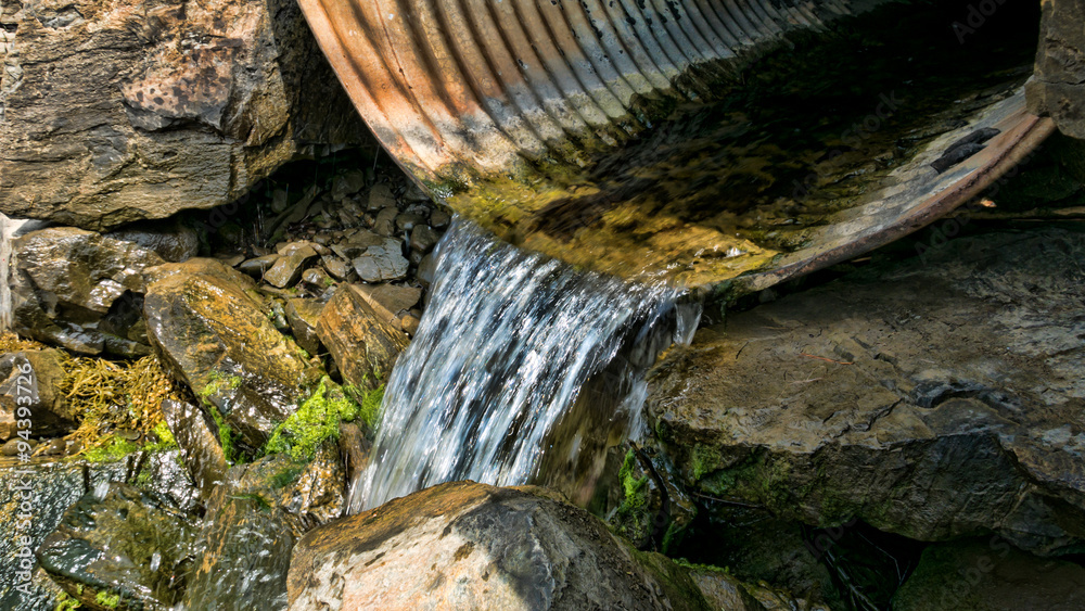 Water draining from a culvert foto de Stock Adobe Stock