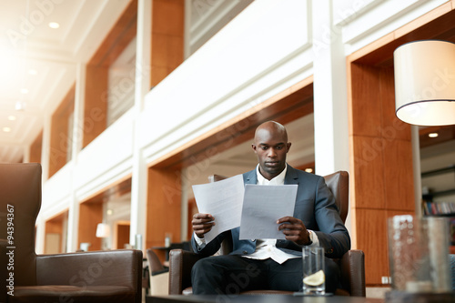 Business executive at lobby reading documents