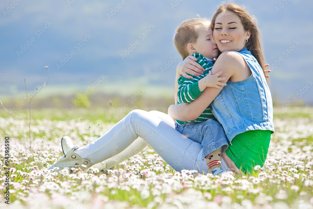 Fototapeta premium Happy mother with son in a flowers field