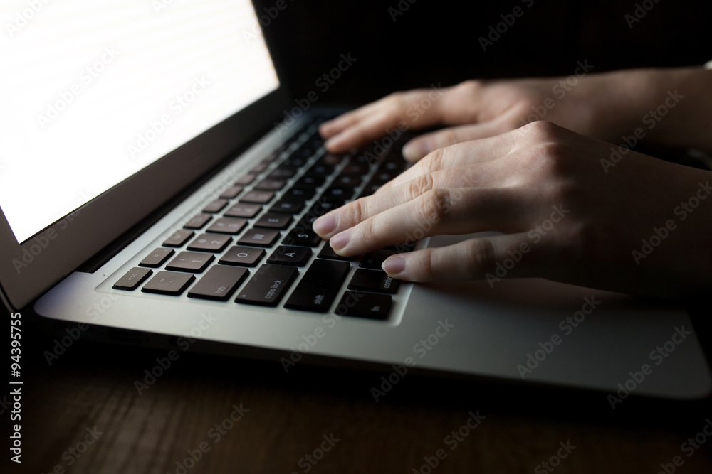 woman hands using laptop at office desk, with copyspace in dark woman hands using laptop at office desk, with copyspace in dark