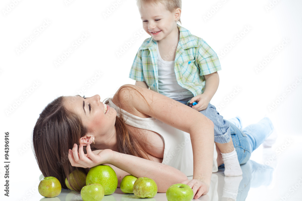 Fototapeta premium Mother with son are eating apples in studio