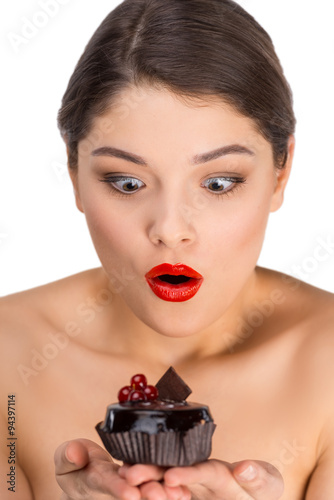 Surprised woman with glossy red lips holding chocolate cake
