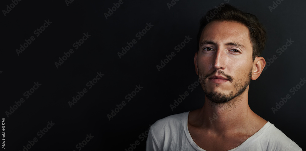 Portrait of cute young man wearing white tshirt and looking serious. Wide