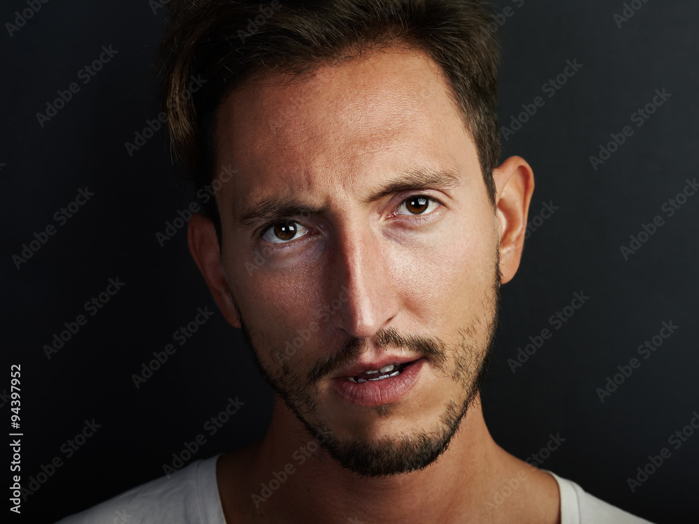 Portrait of young man wearing white tshirt and looks angry. Horizontal Portrait of young man wearing white tshirt and looks angry. Horizontal