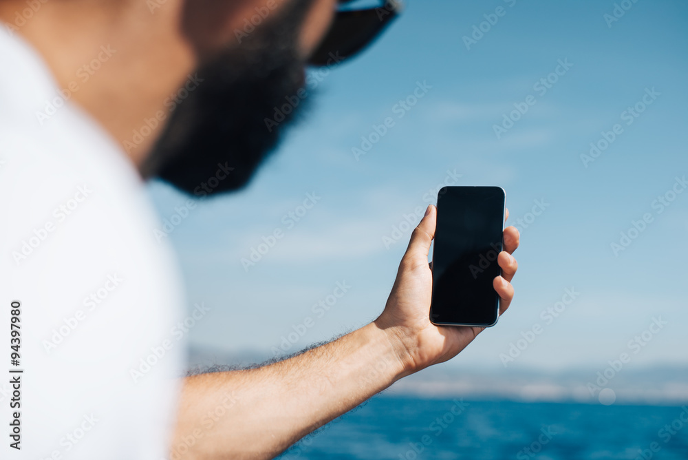 Bearded man makes the selfie on his smartphone.