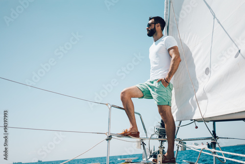 Low angle view of young bearded man standing on the nose yacht © SFIO CRACHO