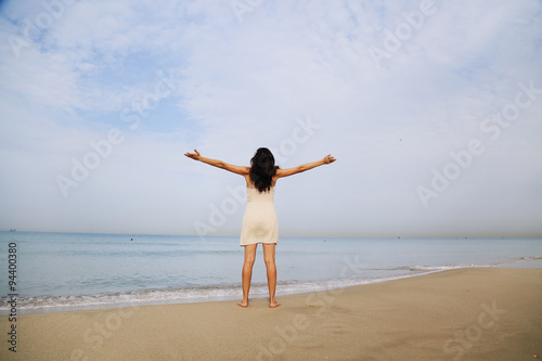 beautiful woman standing on the shore of the beach