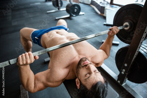 Muscular man doing bench press