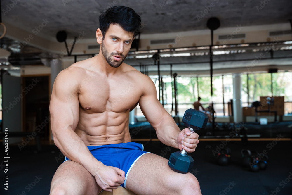 Serious muscular man holding dumbbell Serious muscular man holding dumbbell