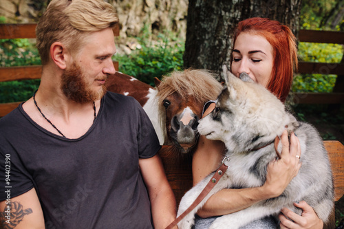 beautiful couple together with dog on a swing