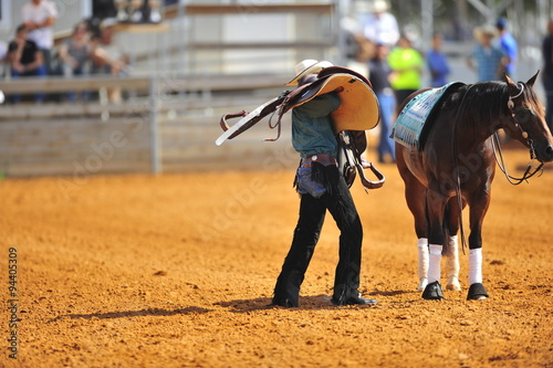 The rider carries a saddle of his horse in thanks for the hard work in the competition