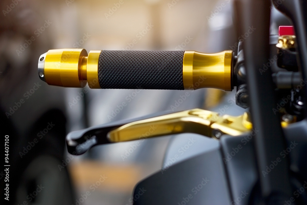 Gold motorcycle handle on street background