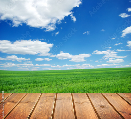  field under blue sky. Wood planks floor