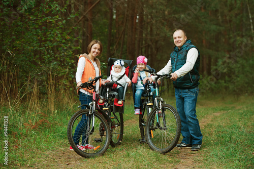 happy family riding bike in wood