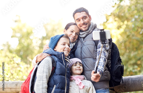 happy family with smartphone selfie stick in woods © Syda Productions