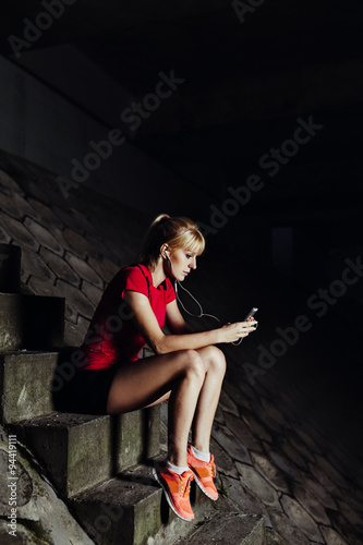 Young woman setting up playlist before run