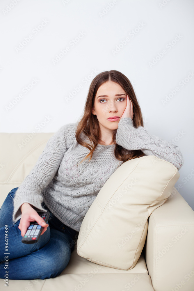 Sad woman watching television and changing channels Sad woman watching television and changing channels
