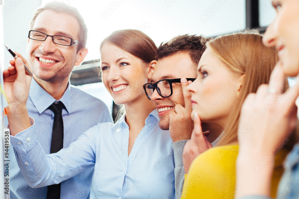 Happy sales reps standing and looking at some results Happy sales reps standing and looking at some results