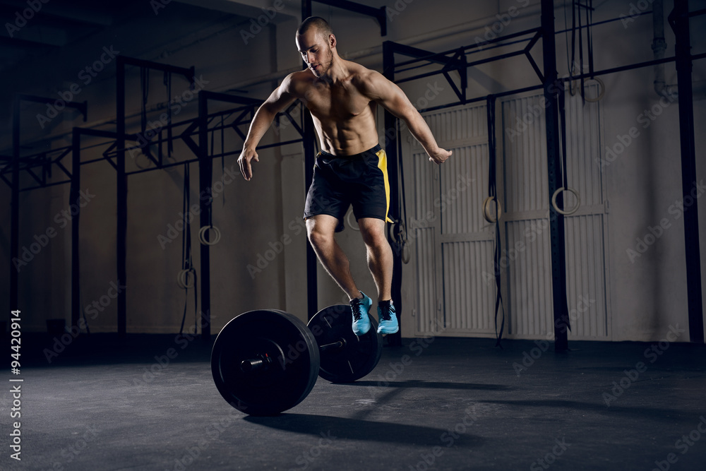 Men jumping over barbells