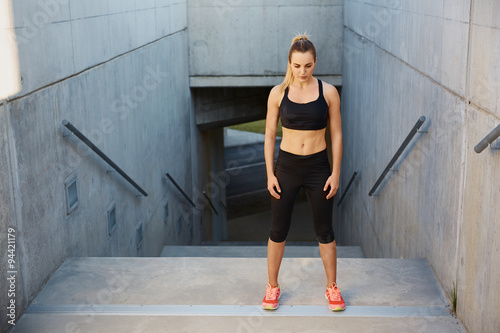 Athletic woman breathe between interval exercise on stairs