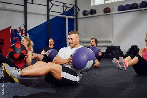 young people training with exercise ball at gym