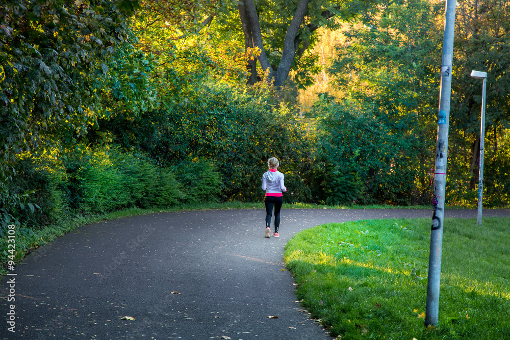 Fototapeta premium Frau läuft und joggt im Park