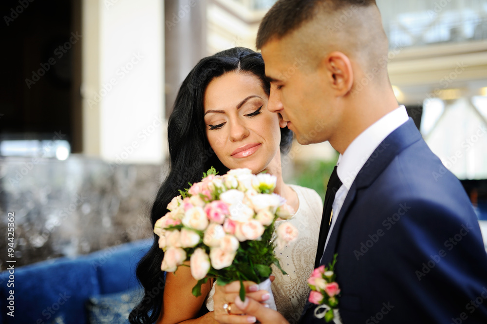 the bride with a wedding bouquet on the background of the groom the bride with a wedding bouquet on the background of the groom