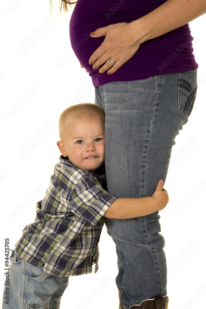 pregnant mom in boots young boy hug her legs close pregnant mom in boots young boy hug her legs close