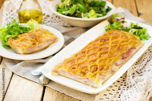 Puff pastry pasty with bechamel sauce, ham and cheese photo