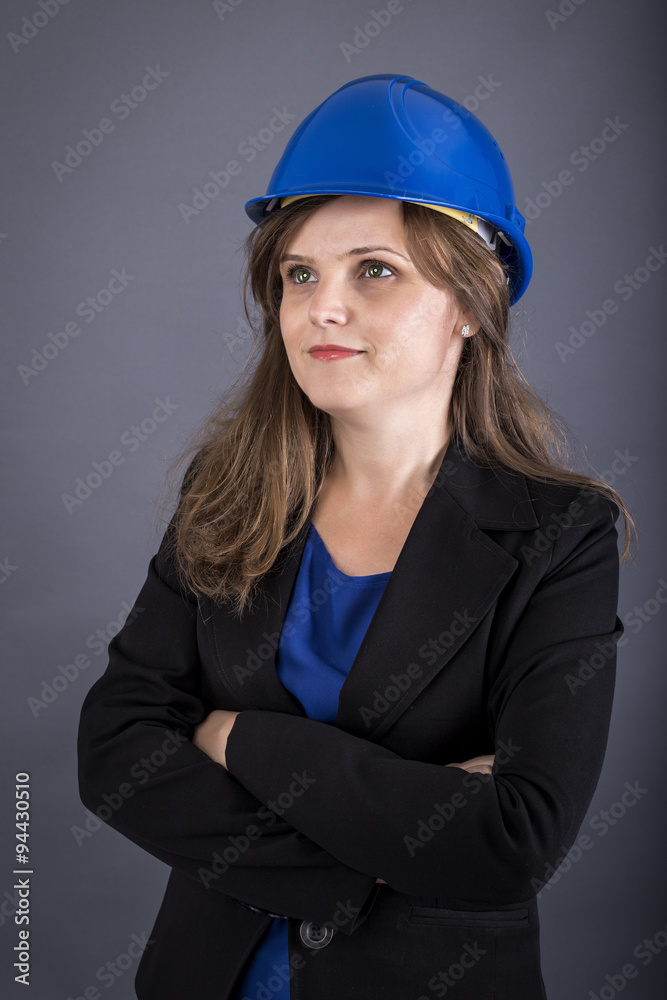 Happy young engineer woman with hardhat and arms folded Happy young engineer woman with hardhat and arms folded
